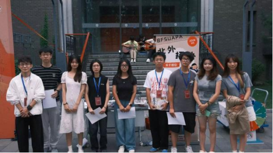 九名组织部志愿者在校园招新摊位前合影